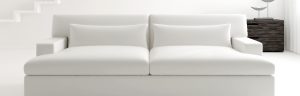 White sofa in white walls and in front of a dark wooden side table