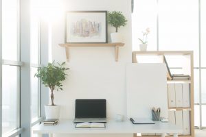 Front view picture of studio workplace with blank notebook, laptop. Designer comfortable work table, home office